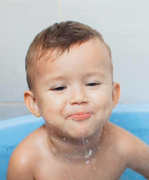 boy taking bath spitting water