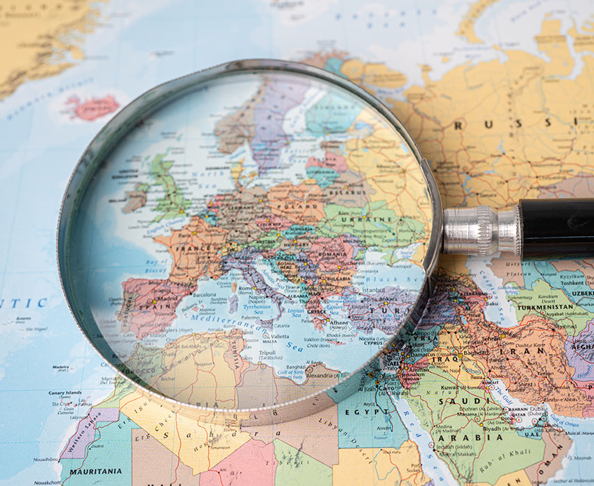 Magnifying glass close up Europe with colorful world map