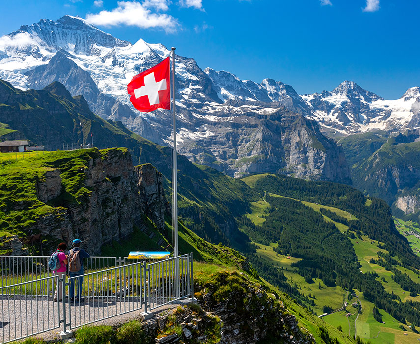 Swiss mountains with a Swiss flag, representing local services across cantons in Switzerland.